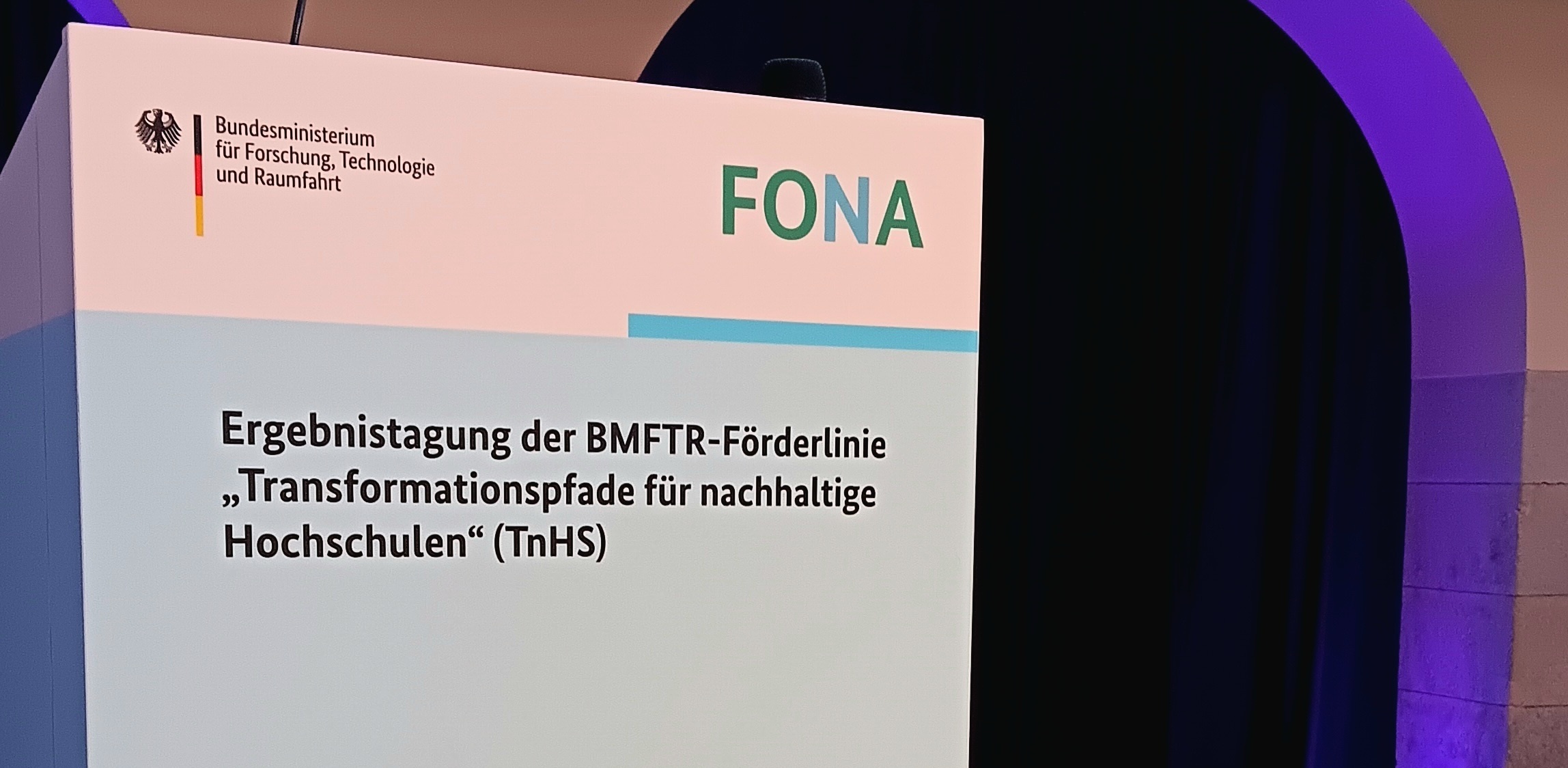 Ergebnistagung Transformationspfade Berlin 2026 Schild am Rednerpult